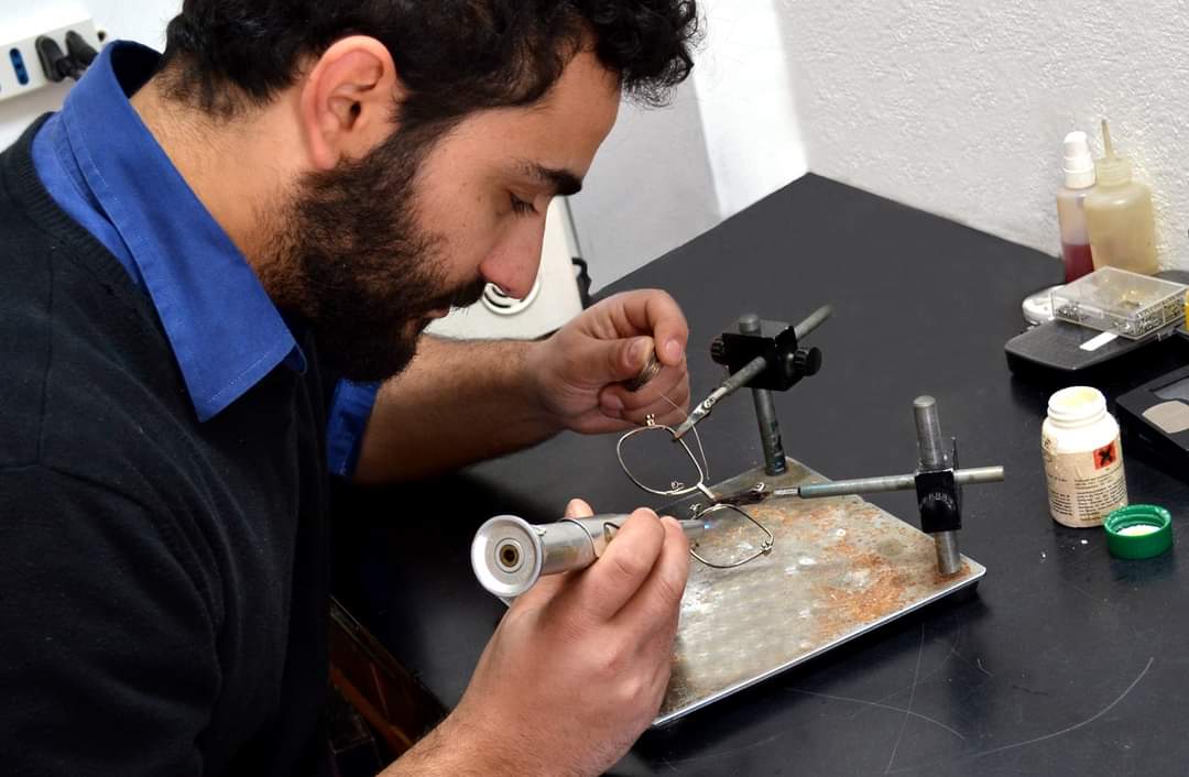Francesco Tolu nel suo laboratorio intento a saldare un occhiale